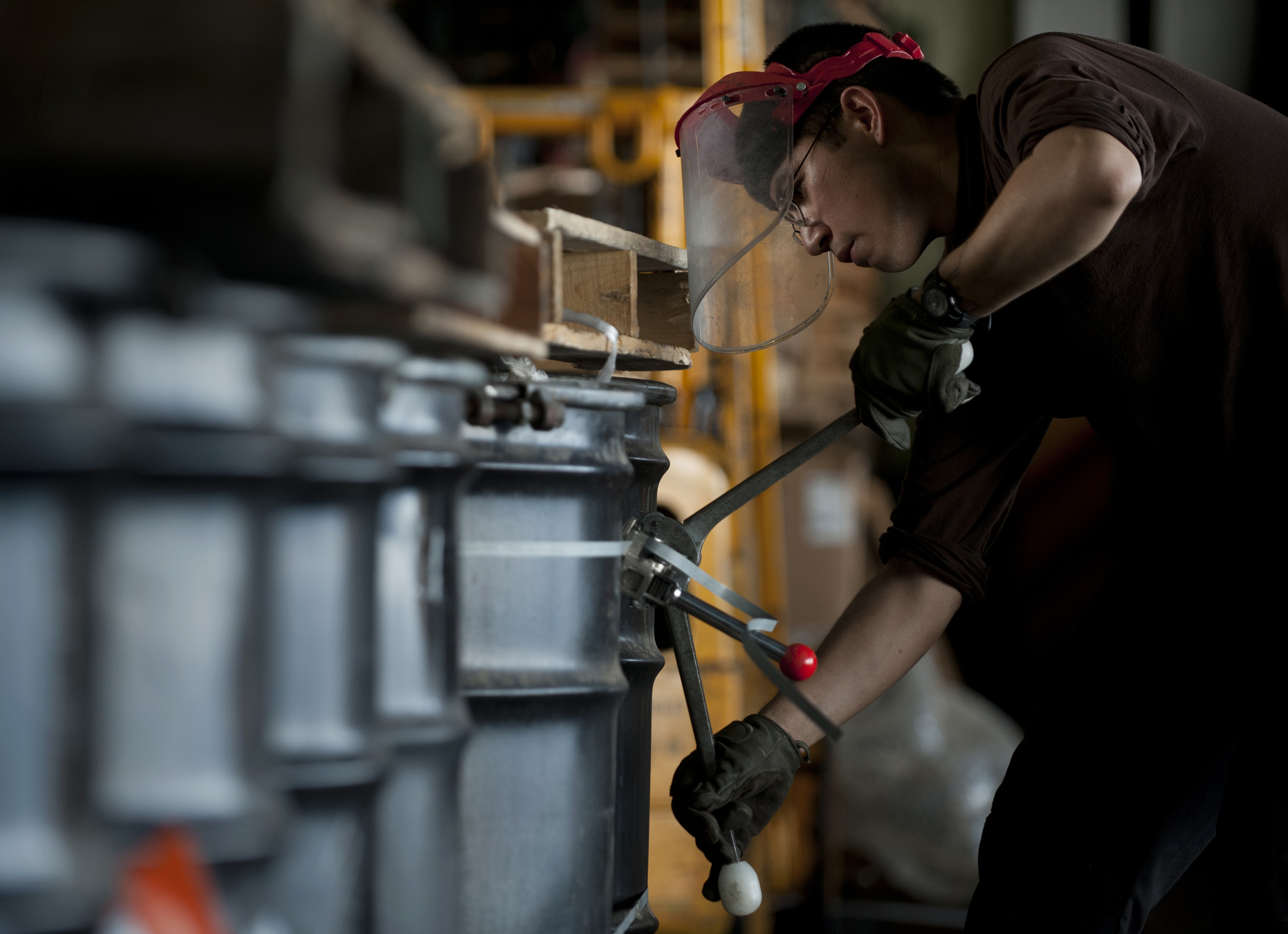 This is an image of a United States Navy Sailor banding barrels of hazardous waste.